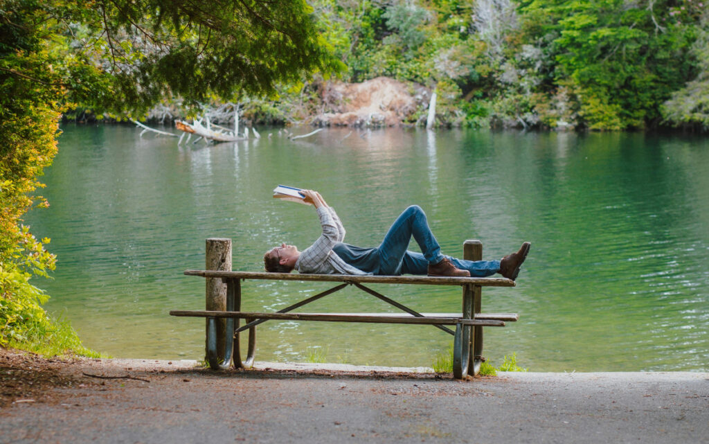 reading a book by the lake