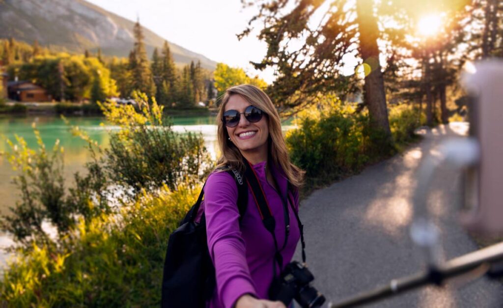 Woman taking selfie by the lake